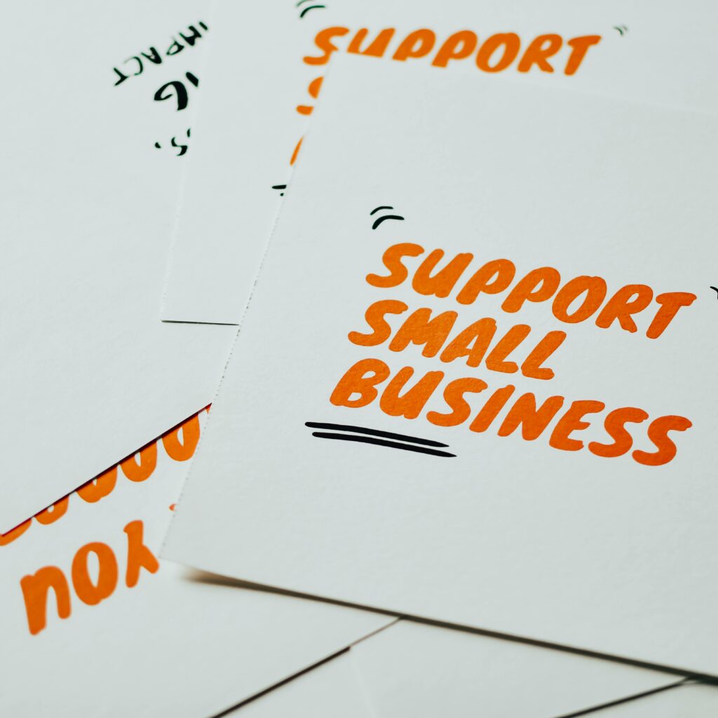 Close-up of motivational cards promoting support for small business on white background.